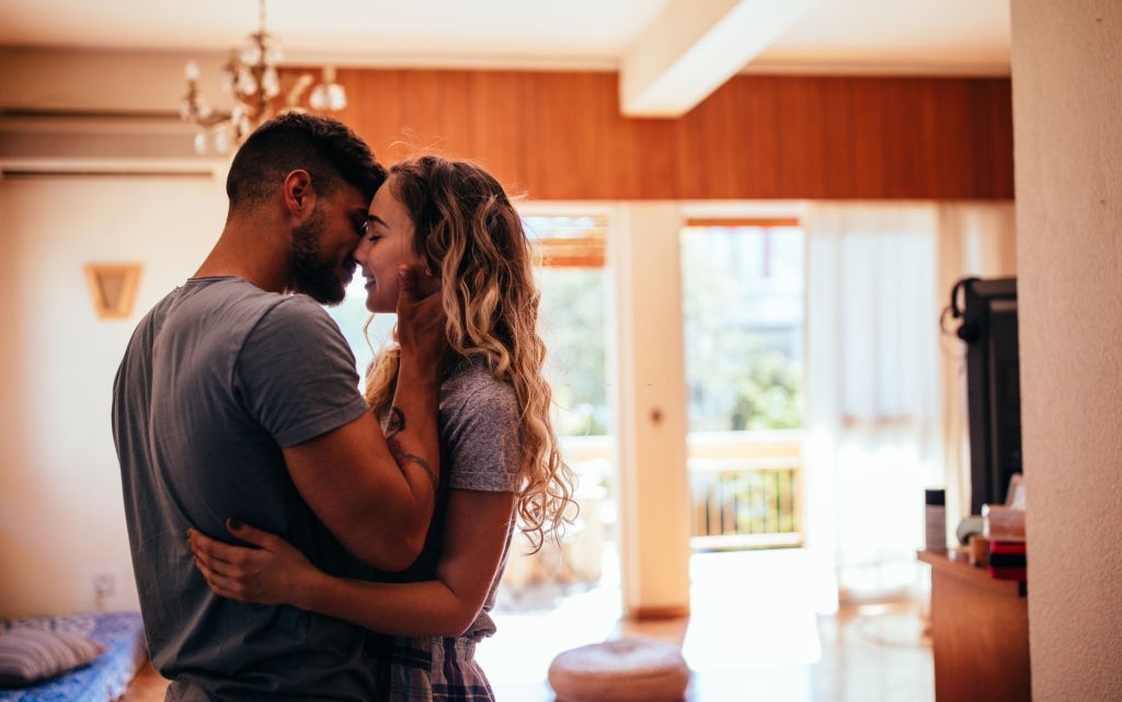 Loving young hipster couple relaxing at home and kissing